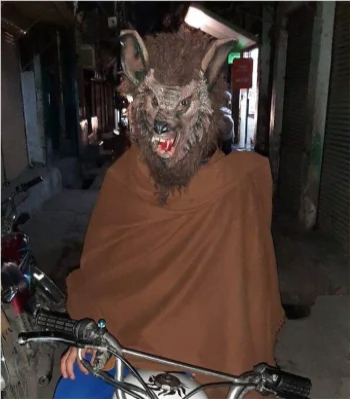 A man with the costume of a wolf on a bike frightening the women and children, Wolfman