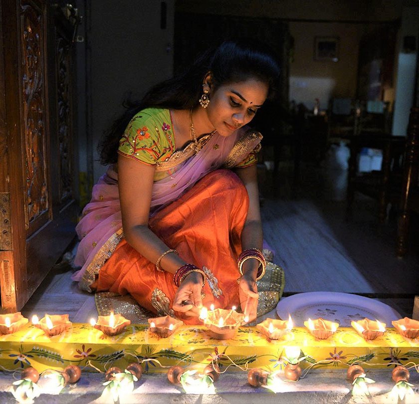 An Indian woman Nikitha places earthen lamps or 'diyas' at the entrance of her home on the eve of Diwali Festival in Hyderabad on October 18, 2017. Diwali, the Hindu festival of lights, marks the triumph of good over evil and commemorates the return of Hindu deity Rama to his birthplace Ayodhya after victory against the demon king Ravana